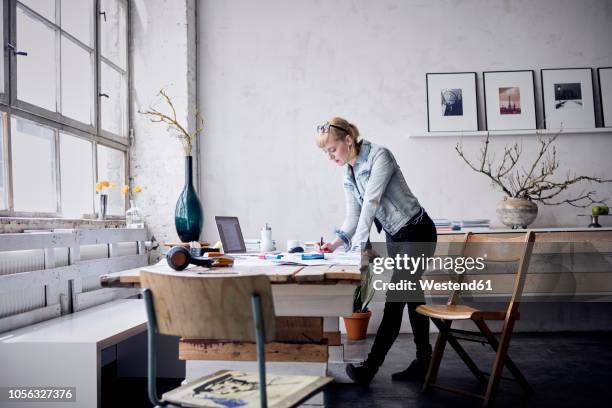 woman working at desk in a loft - anrichte stock-fotos und bilder
