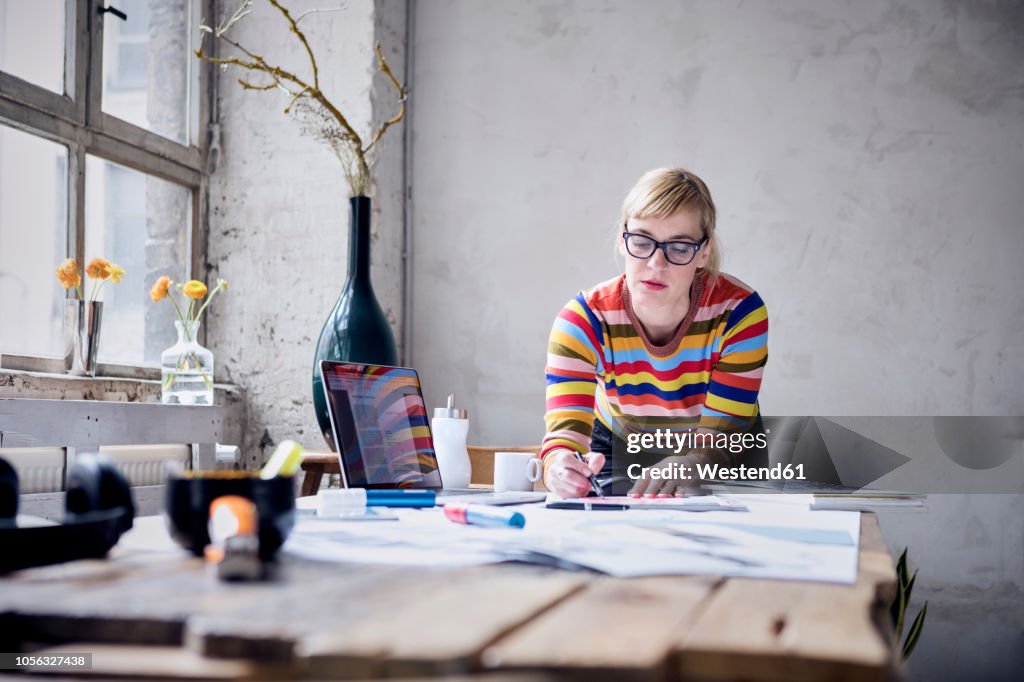 Portrait of woman working at desk in a loft