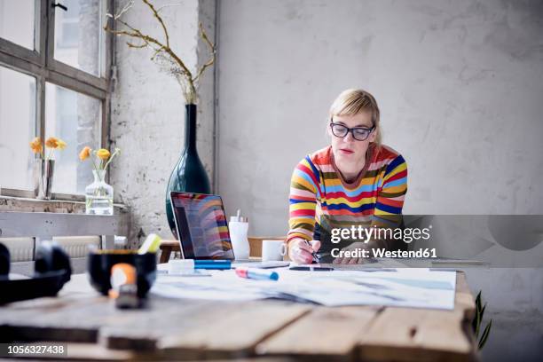 portrait of woman working at desk in a loft - 自由工作者 個照片及圖片檔