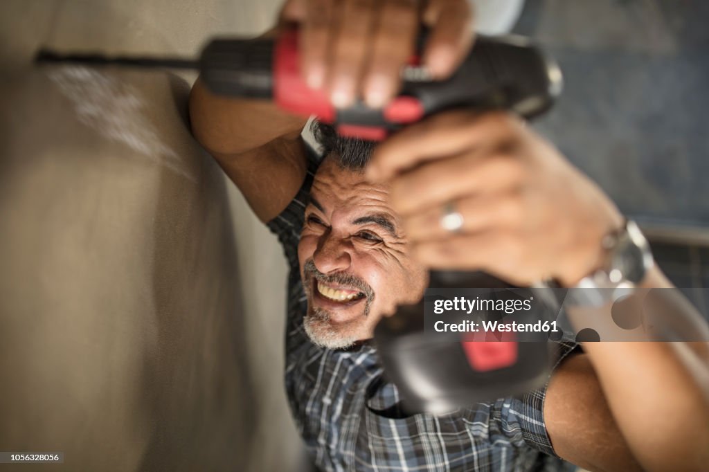 Man drilling into wall