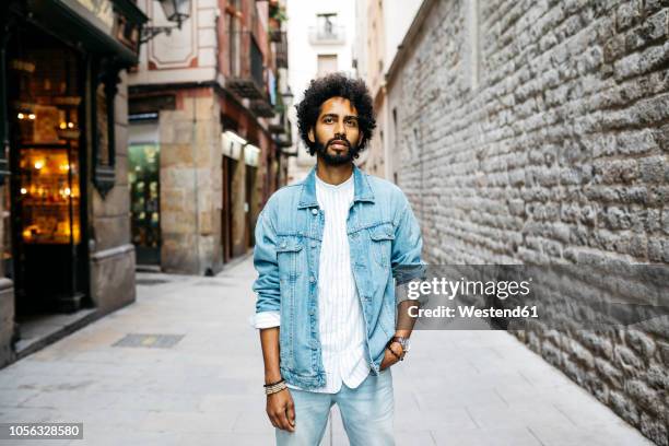 spain, barcelona, portrait of bearded young man with curly hair - veste homme photos et images de collection