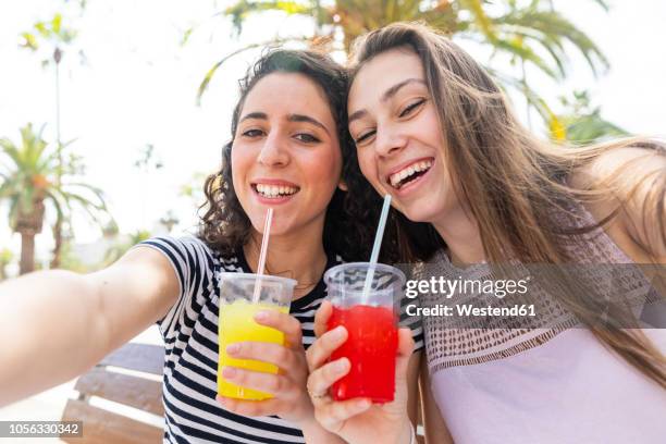 portrait of two happy female friends enjoying a fresh slush - frozen drink stock pictures, royalty-free photos & images