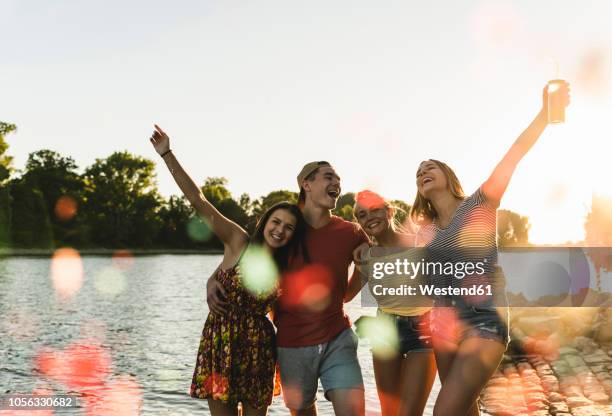 group of happy friends having fun in a river at sunset - summer comedies party stockfoto's en -beelden