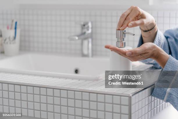 close-up of woman wputting soap on her hands in bathroom - soap dispenser stock pictures, royalty-free photos & images