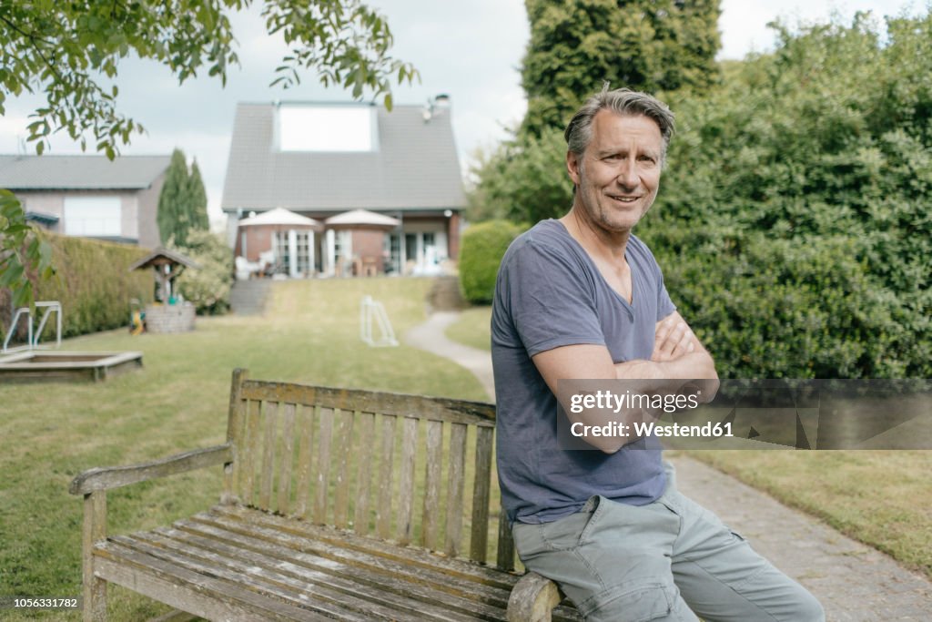 Portrait of smiling mature man in garden of his home