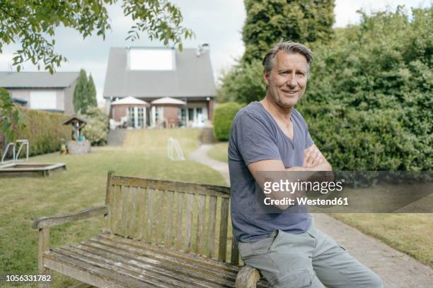 portrait of smiling mature man in garden of his home - männer über 40 stock-fotos und bilder