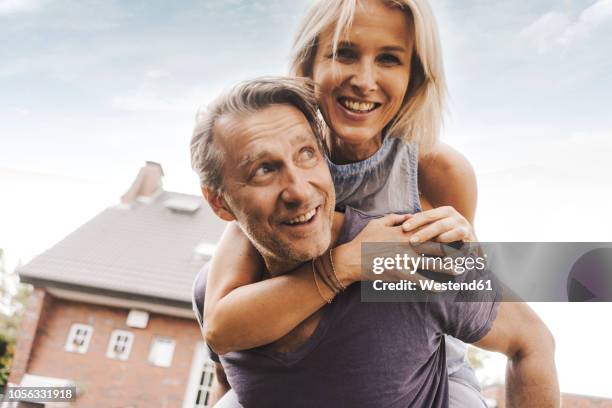 happy mature couple in front of their home - middle class female stock pictures, royalty-free photos & images