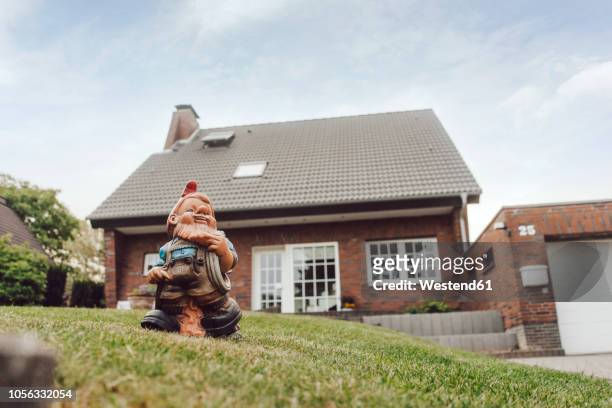 garden gnome in garden of one-family house - gnomo da giardino foto e immagini stock