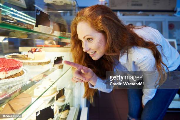 woman choosing cake at cafe - food decisions stock pictures, royalty-free photos & images