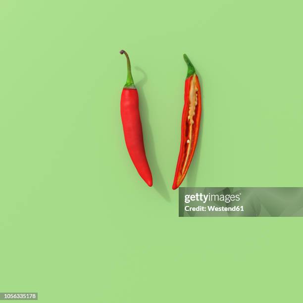 3d rendering, sliced red chili on green background - scharfe schoten stock-grafiken, -clipart, -cartoons und -symbole