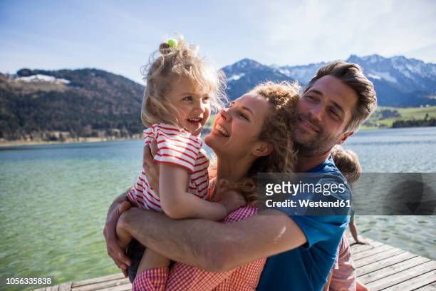 austria, tyrol, walchsee, happy family hugging on a jetty at the lakeside - day 4 stock-fotos und bilder