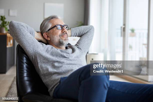 portrait of mature man relaxing at home - paz interior fotografías e imágenes de stock