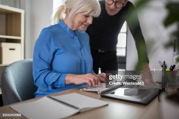 two senior colleagues working together at desk in office - old keyboard stock pictures, royalty-free photos & images
