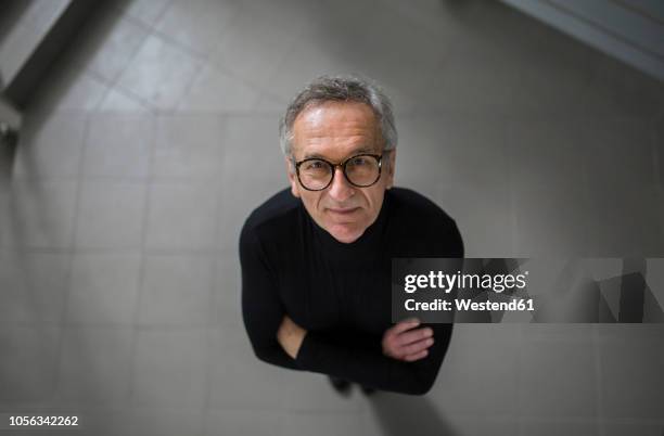 smiling senior businessman looking up on office hallway - omhoog kijken stockfoto's en -beelden