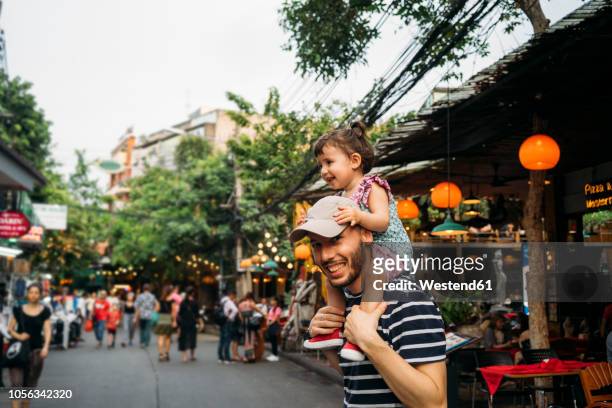 thailand, bangkok, portrait of smiling father and daughter on khao san road - thailand tourist stock pictures, royalty-free photos & images
