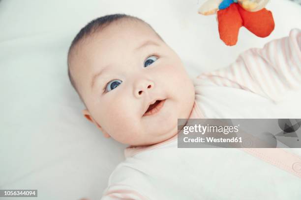 smiling baby lying on bed, portrait - cross eyed 個照片及圖片檔