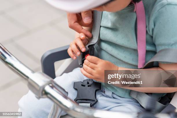 mother and daughter, daughter sitting in children's seat and fastening seat belt - strap stock pictures, royalty-free photos & images
