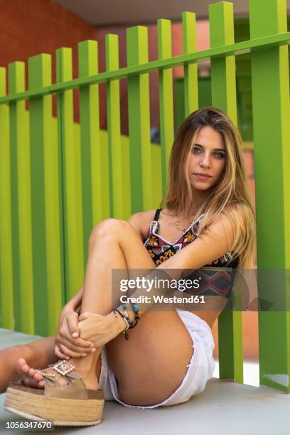 portrait of a pretty blond young woman sitting - platform shoe stock pictures, royalty-free photos & images