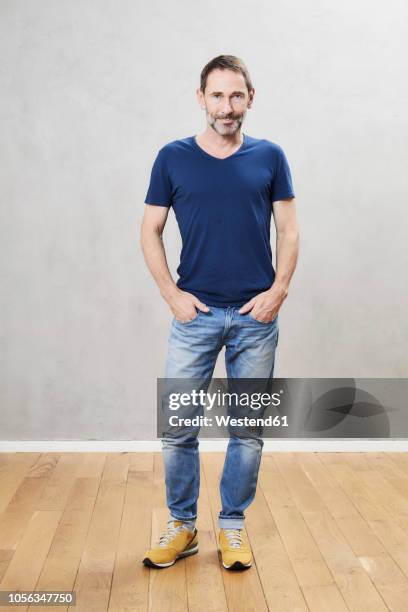 mature man standing on wooden floor - blue tshirt stock pictures, royalty-free photos & images