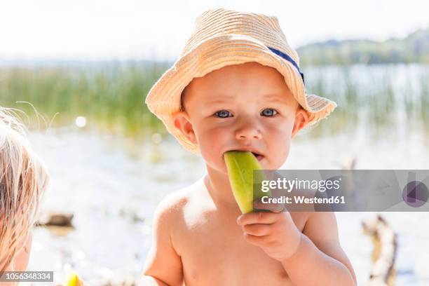 baby boy eating melon at lake - one and a half summer stock pictures, royalty-free photos & images