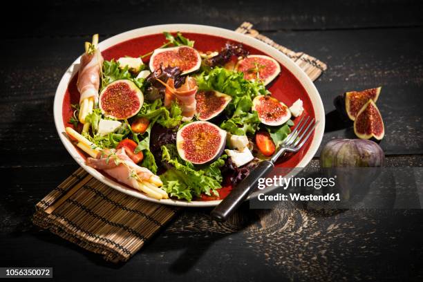 mixed salad with figs, tomatoes, sheep cheese, grissini with ham on plate - garden salad stock pictures, royalty-free photos & images