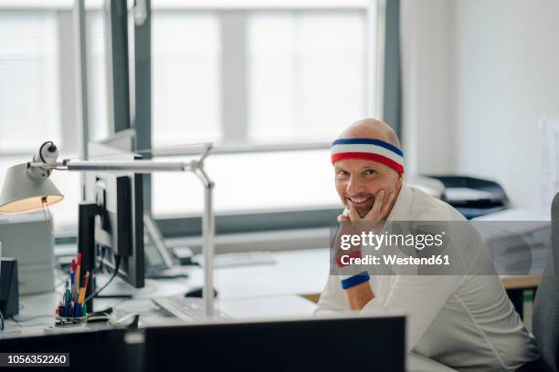 businessman sitting in office, wearing sweat bands - sweat band stock pictures, royalty-free photos & images