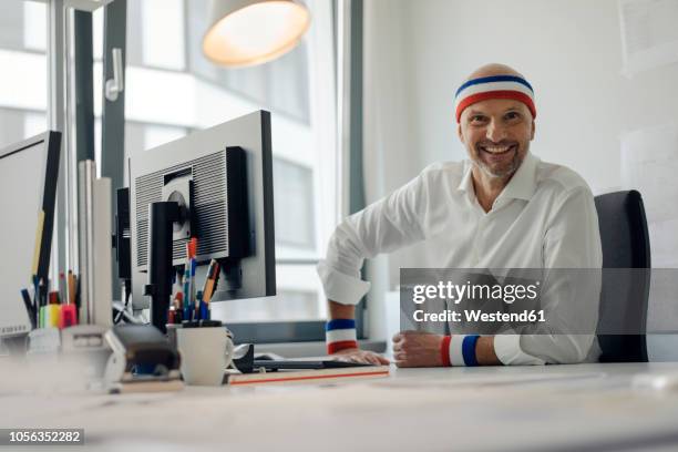 businessman sitting in office, wearing sweat bands - roupa desportiva imagens e fotografias de stock