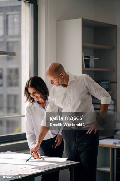 two architects working in office, discussing blueprints - 2018 blueprint stock-fotos und bilder
