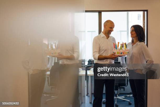 businessman gifting his colleague with a birthday cake in office - luxury lounges stock pictures, royalty-free photos & images