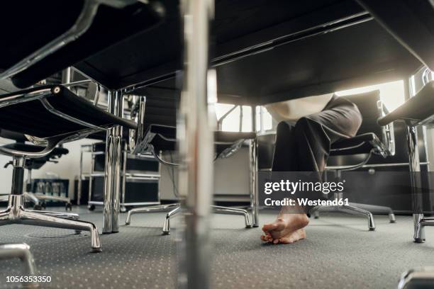 bare feet of businesswoman under her desk - businesswoman barefoot stock-fotos und bilder