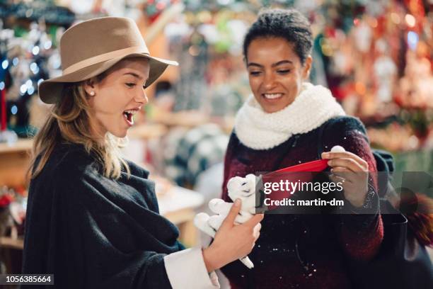 friends shopping for christmas/ new year - woman picking up toys stock pictures, royalty-free photos & images