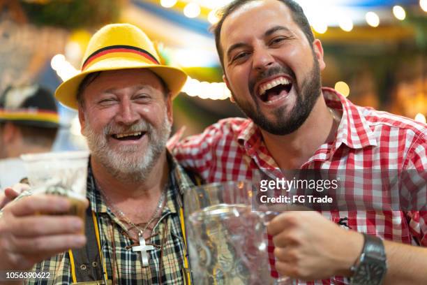 father and son celebrating at beer fest in blumenau, santa catarina, brazil - oktoberfest 2018 stock pictures, royalty-free photos & images