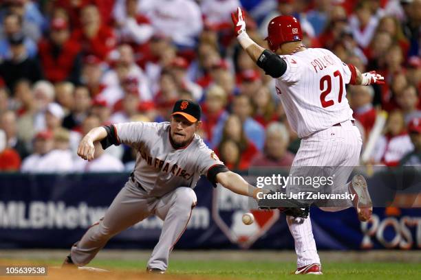 Placido Polanco of the Philadelphia Phillies reaches first safely when Aubrey Huff of the San Francisco Giants can't handle a bad throw to first in...