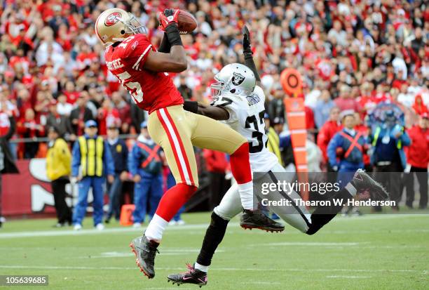 Michael Crabtree of the San Francisco 49ers catches this touchdown pass over Chris Johnson of the Oakland Raiders during an NFL football game at...