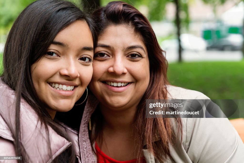 Latijns-Amerikaanse moeder en tennage dochter portret buitenshuis.