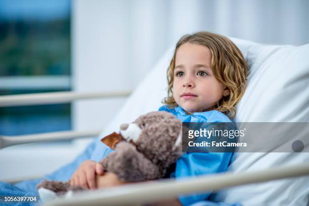 junges mädchen liegen in einem krankenhausbett stoisch suchen - child in hospital stock-fotos und bilder