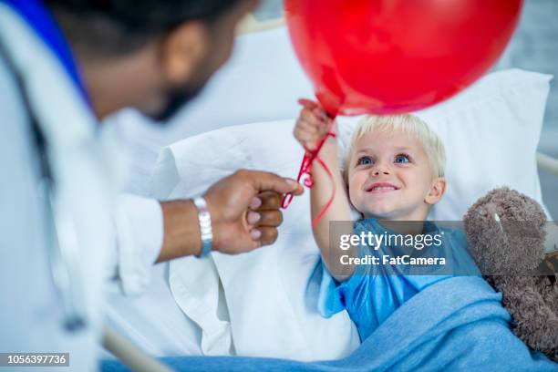 jonge ziekenhuis patiënt krijgt een ballon van zijn arts met vreugde - balloon kid stockfoto's en -beelden