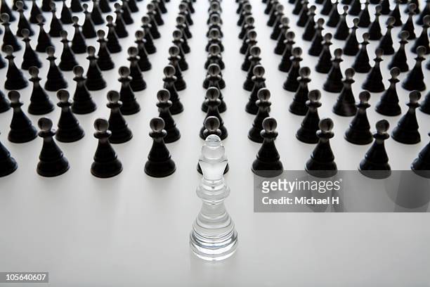 white king who governs a black pawn - chess pawn against stockfoto's en -beelden