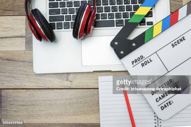 video editing,office stuff with movie clapper laptop - film script stock-fotos und bilder