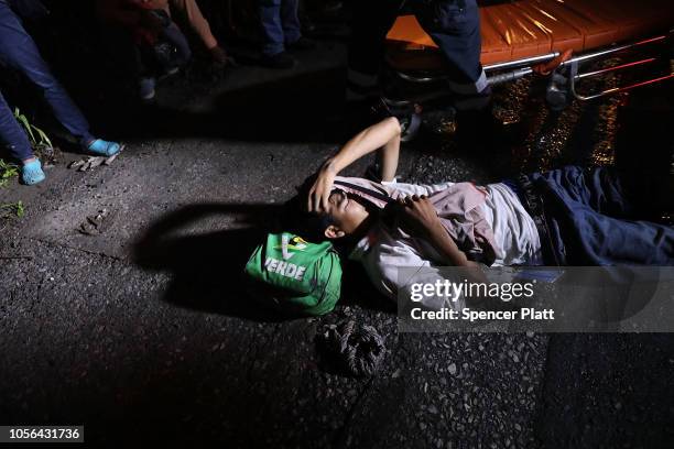 Salvadorian man is aided by medical workers after cutting his leg while trying to jump on a truck as the Central American migrant caravan moves in...