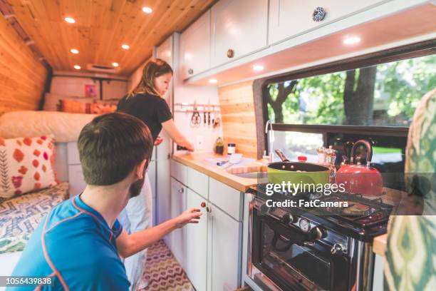 millennial couple cook breakfast in the van they live in - vehicle interior stock pictures, royalty-free photos & images