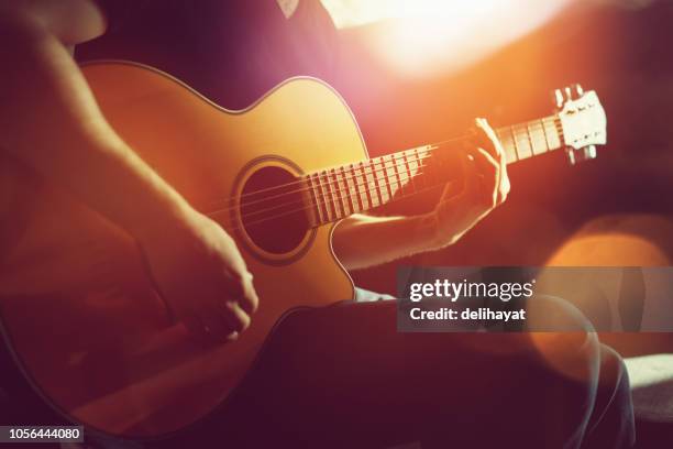 het beoefenen van akoestische gitaar - acoustic music stockfoto's en -beelden