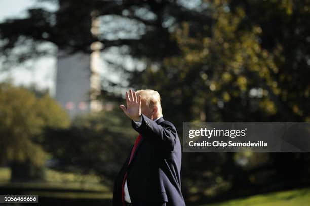 President Donald Trump waves to journalists as he walks across the South Lawn before boarding Marine One and departing the White House October 18,...