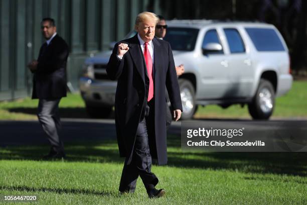 President Donald Trump pumps his fist as he walks across the South Lawn before boarding Marine One and departing the White House October 18, 2018 in...