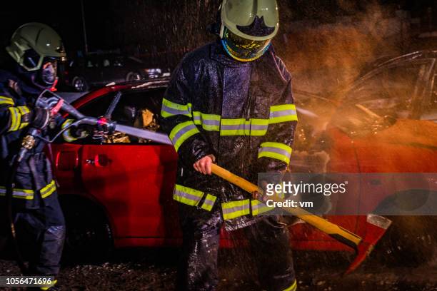 fireman with an axe at a traffic accident - fireman axe stock pictures, royalty-free photos & images