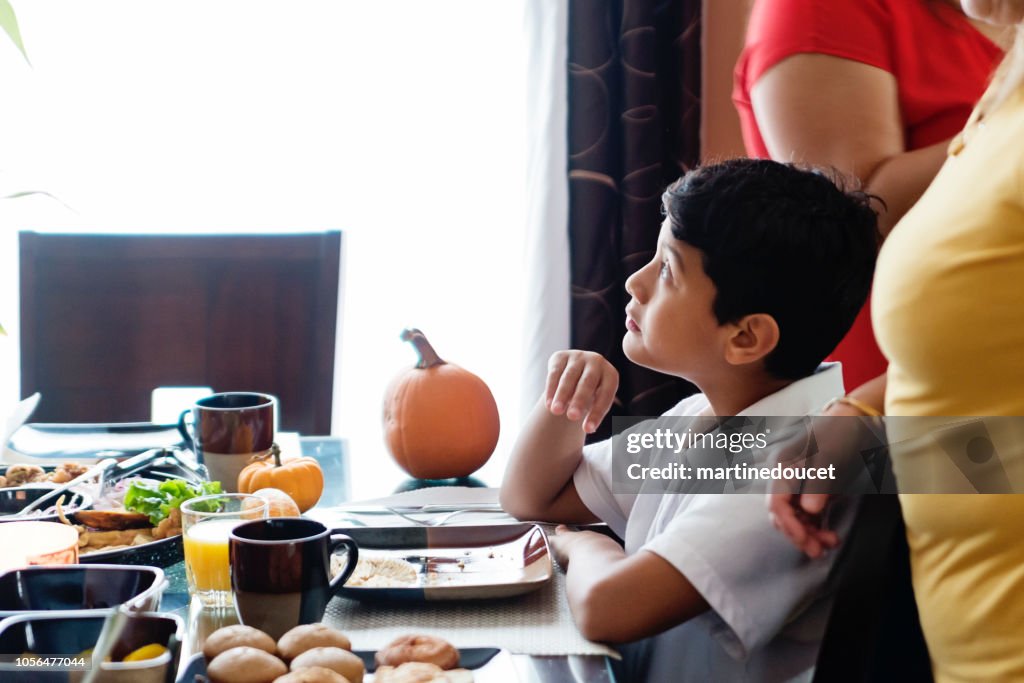 América Latina preadolescente muchacho sentado en la mesa familiar.