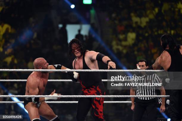 Kane vies with Triple H during a tag team match as part of as part of the World Wrestling Entertainment Crown Jewel pay-per-view at the King Saud...