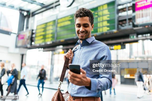 brazilian businessman at the airport checking the flight - i phone airplane ticket stock pictures, royalty-free photos & images