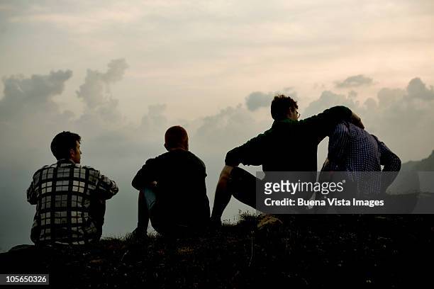 four men on the ridge of a mountain - four people foto e immagini stock