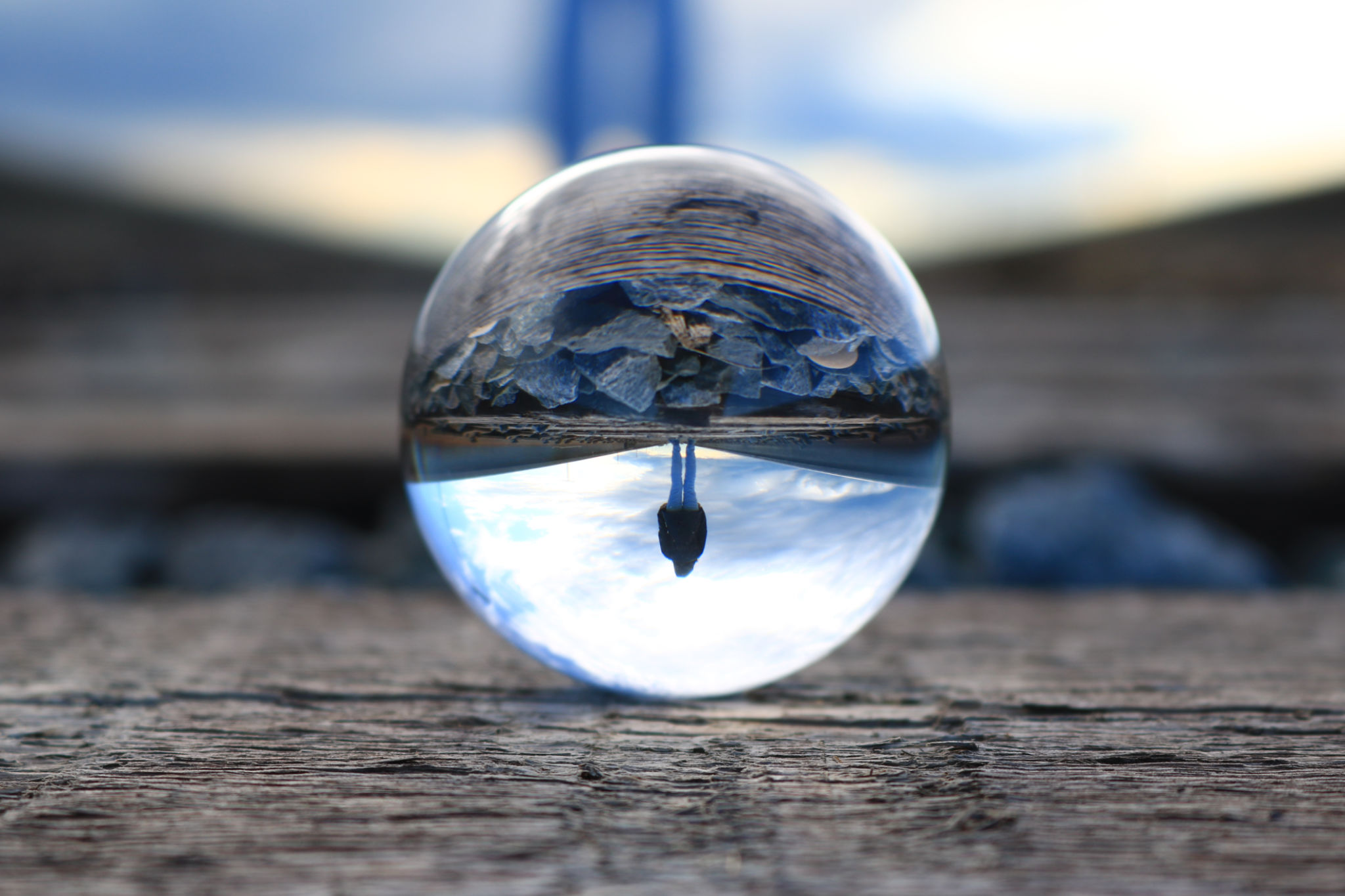 Refection of a woman walking on the train tracks in a lens ball Refection of a woman walking on the train tracks in a lens ball